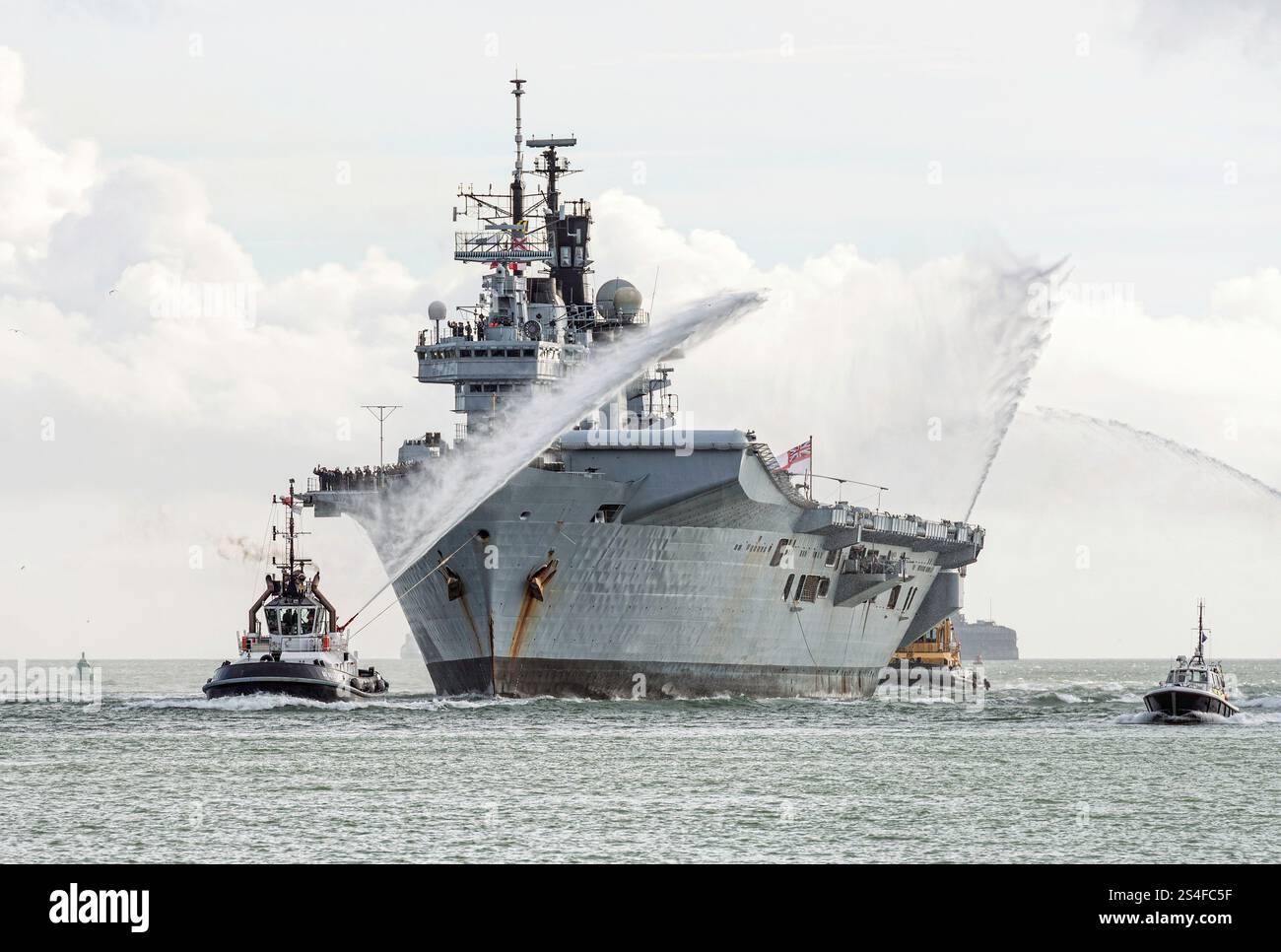 HMS illustrious (R06) erhält eine Schleppereskorte bei der Rückkehr nach Portsmouth vom Einsatz. Der Flugzeugträger wurde im August 2014 stillgelegt. Stockfoto
