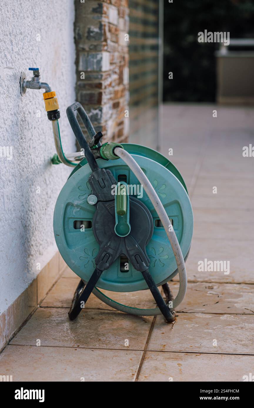 Schlauchtrommel für die Bewässerung des Gartens in einem Garten auf dem Land Stockfoto