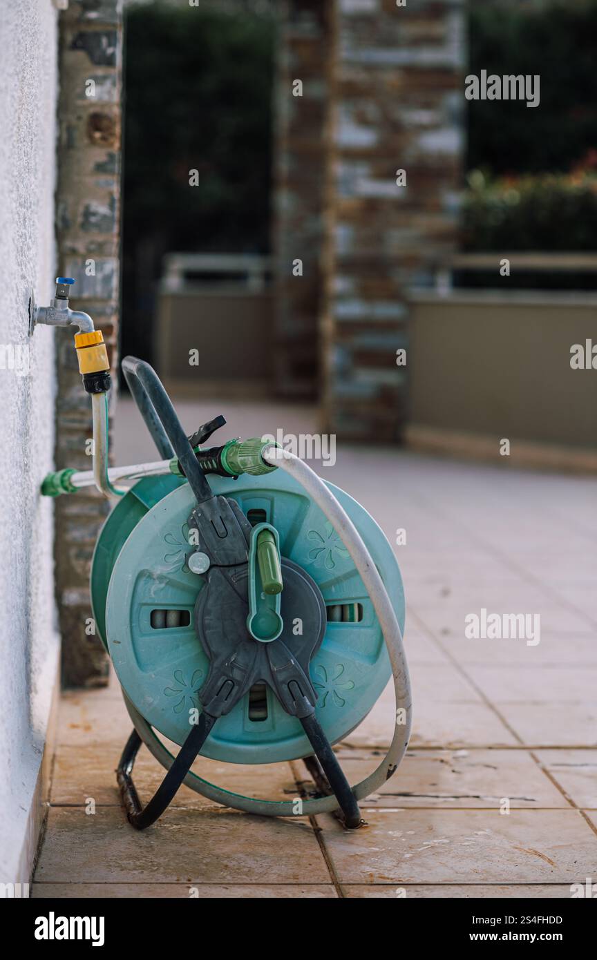 Schlauchtrommel für die Bewässerung des Gartens in einem Garten auf dem Land Stockfoto