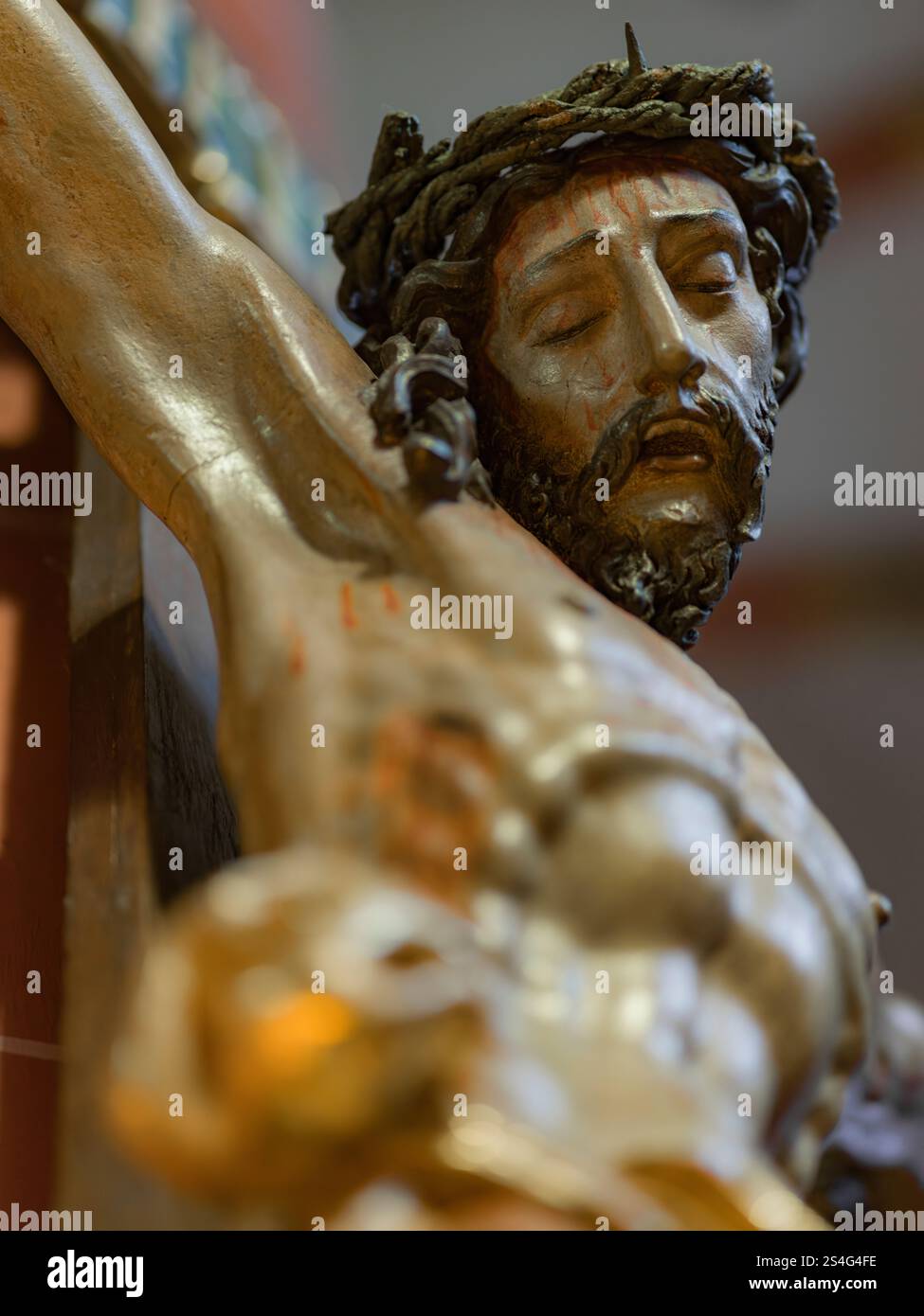 Eine detaillierte Darstellung Jesu am Kreuz, die seinen ruhigen, aber leidenden Ausdruck unterstreicht, ein zeitloses Symbol für Opfer, Glauben und göttliche Gnade. Stockfoto