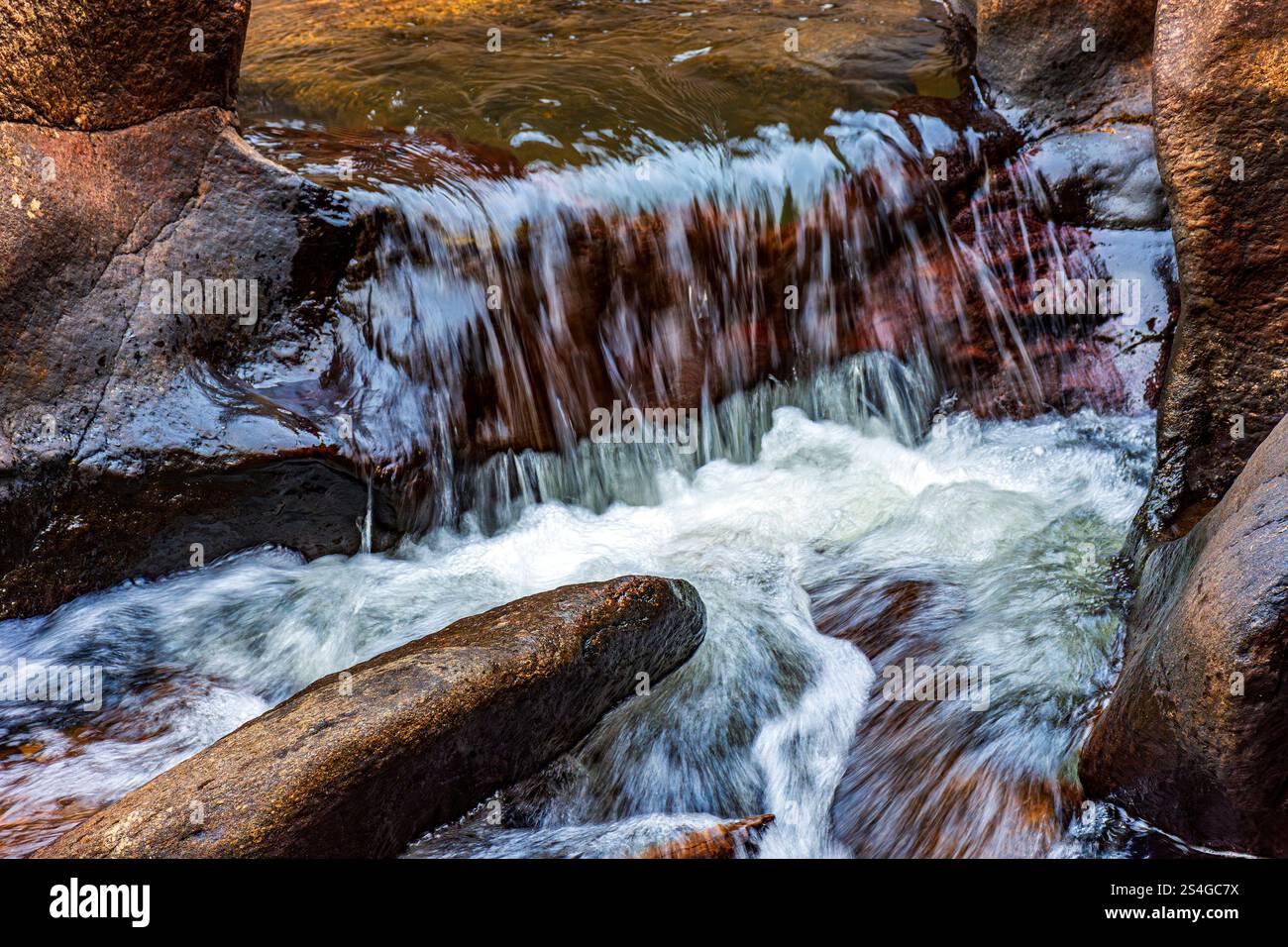 Kleiner Fluss und Kaskade mit Wasser, das zwischen den Felsen fließt Stockfoto