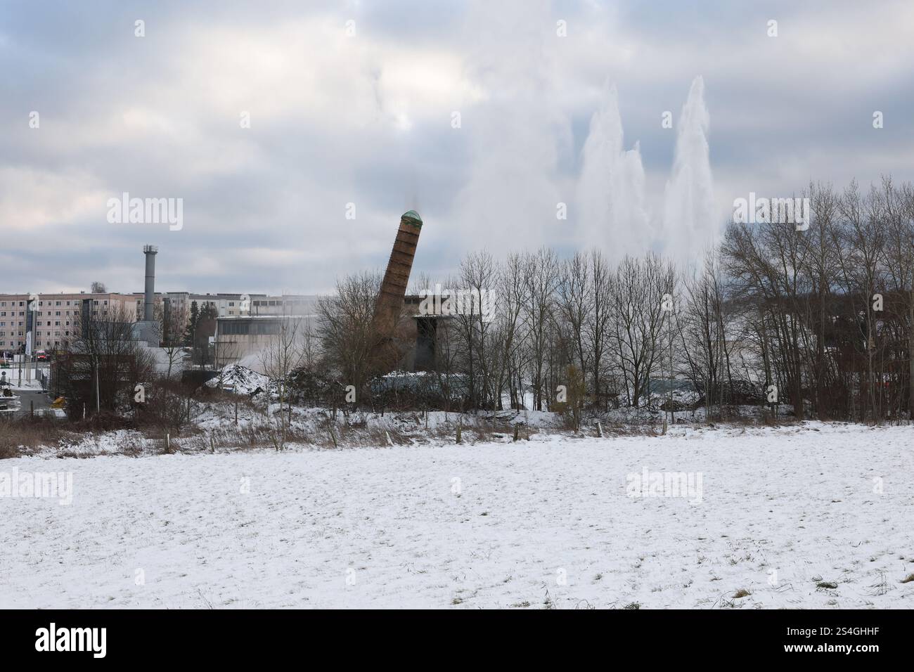 Eisenberg, Deutschland. Januar 2025. Ein 60 Meter hoher Schornstein wurde mit acht bis zehn Kilogramm Eurodyn-Sprengstoff gesprengt. Der Schornstein befindet sich auf dem Gelände des zukünftigen Servicezentrums des Saale-Holzland-Bezirks. Der Neubau soll verschiedene Büros und Abteilungen des Bezirks an einem zentralen Ort zusammenführen. Quelle: Bodo Schackow/dpa/Alamy Live News Stockfoto
