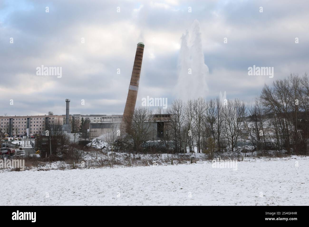 Eisenberg, Deutschland. Januar 2025. Ein 60 Meter hoher Schornstein wurde mit acht bis zehn Kilogramm Eurodyn-Sprengstoff gesprengt. Der Schornstein befindet sich auf dem Gelände des zukünftigen Servicezentrums des Saale-Holzland-Bezirks. Der Neubau soll verschiedene Büros und Abteilungen des Bezirks an einem zentralen Ort zusammenführen. Quelle: Bodo Schackow/dpa/Alamy Live News Stockfoto