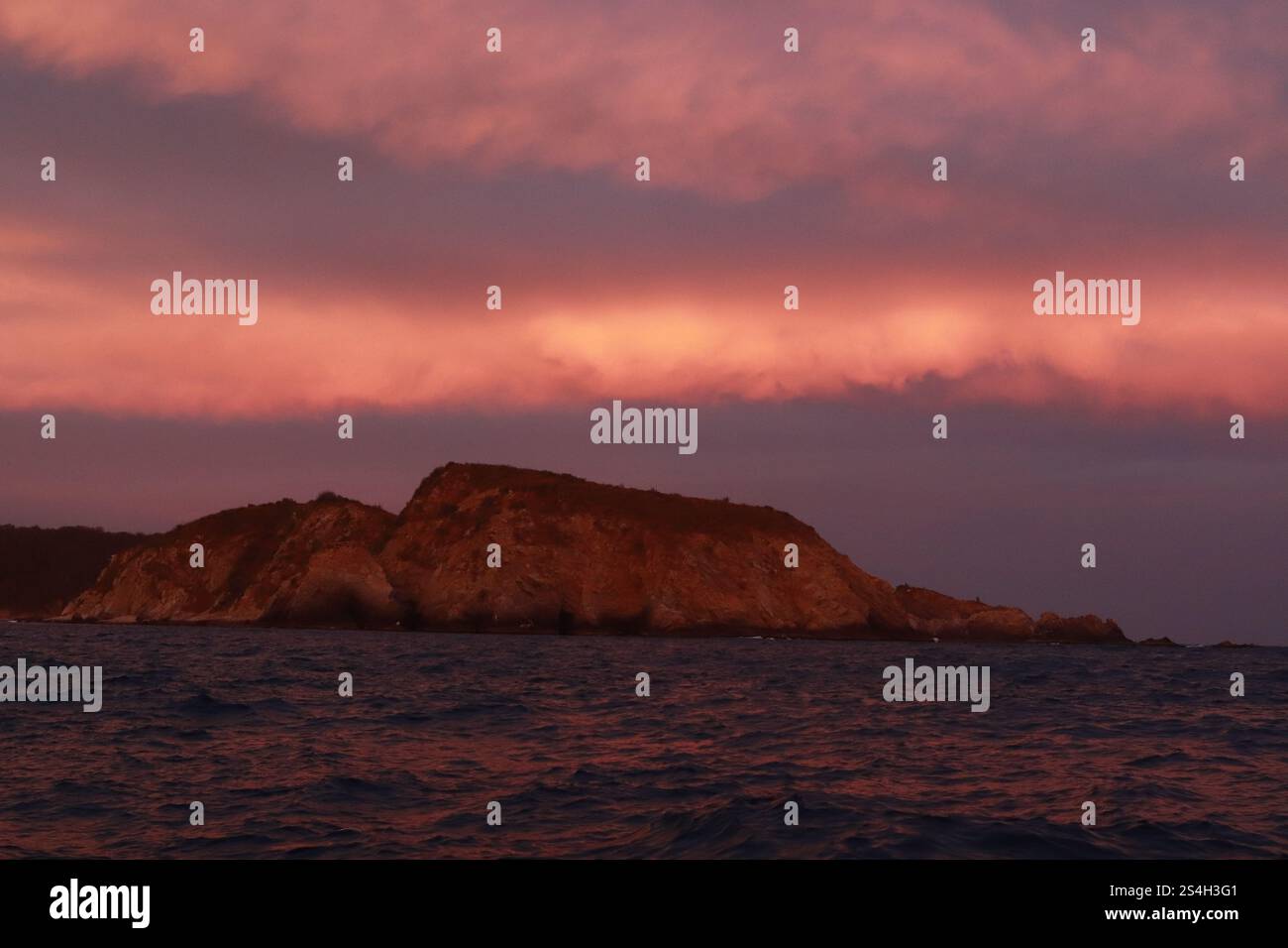 Die Berge werden durch den Sonnenuntergang in der Nähe der Bucht von Cacaluta, Teil des Huatulco National Reserve, in Santa Maria Huatulco gesehen. Huatulco Nationalpark Stockfoto