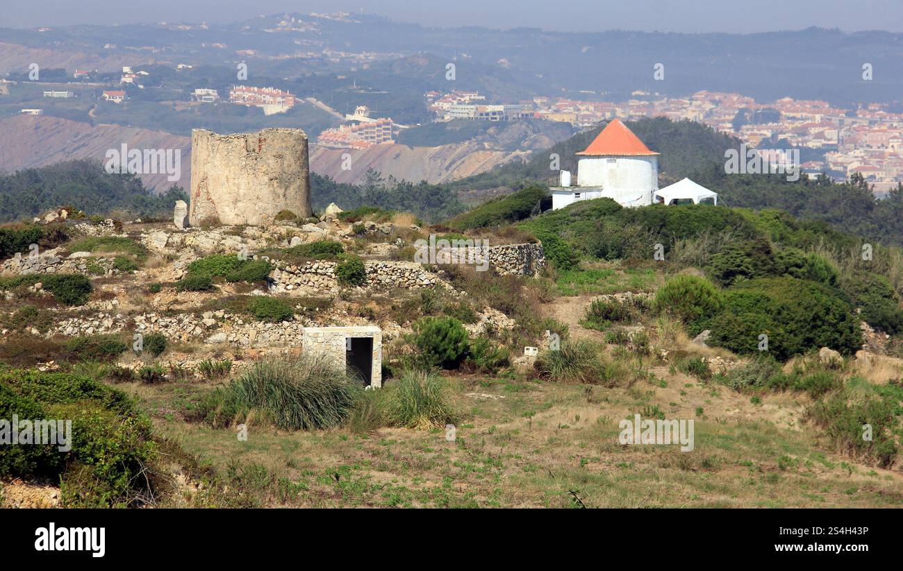 Ruinen einer alten Windmühle in Sao Martinho Cove do Porto, Bucht von Sao Martinho do Porto im Hintergrund, Salir do Porto, Portugal Stockfoto