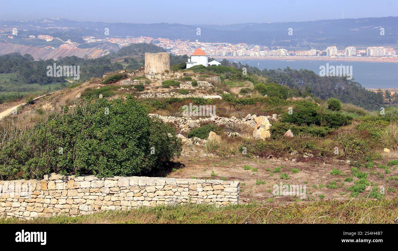 Ruinen einer alten Windmühle in Sao Martinho Cove do Porto, Bucht von Sao Martinho do Porto im Hintergrund, Salir do Porto, Portugal Stockfoto