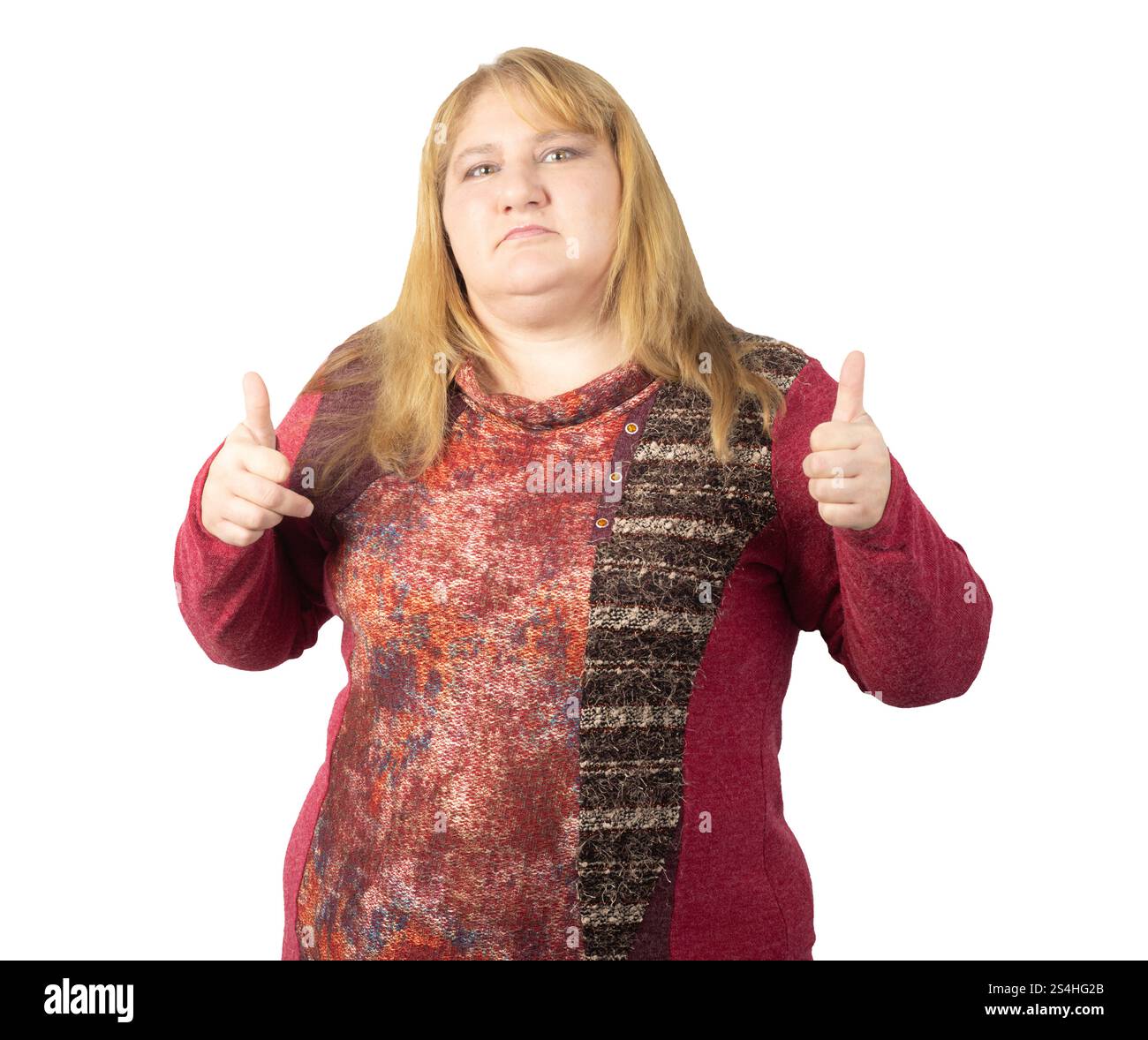 Eine Frau mittleren Alters, die ihre Zustimmung mit einer doppelten Daumen-nach-oben-Geste ausdrückt. Sie trägt einen gemusterten roten Pullover und hat einen ernsthaften Ausdruck. Stockfoto Eine Frau mittleren Alters, die ihre Zustimmung mit einer doppelten Daumen-nach-oben-Geste ausdrückt. Sie trägt einen gemusterten roten Pullover und hat einen ernsthaften Ausdruck. Stockfoto