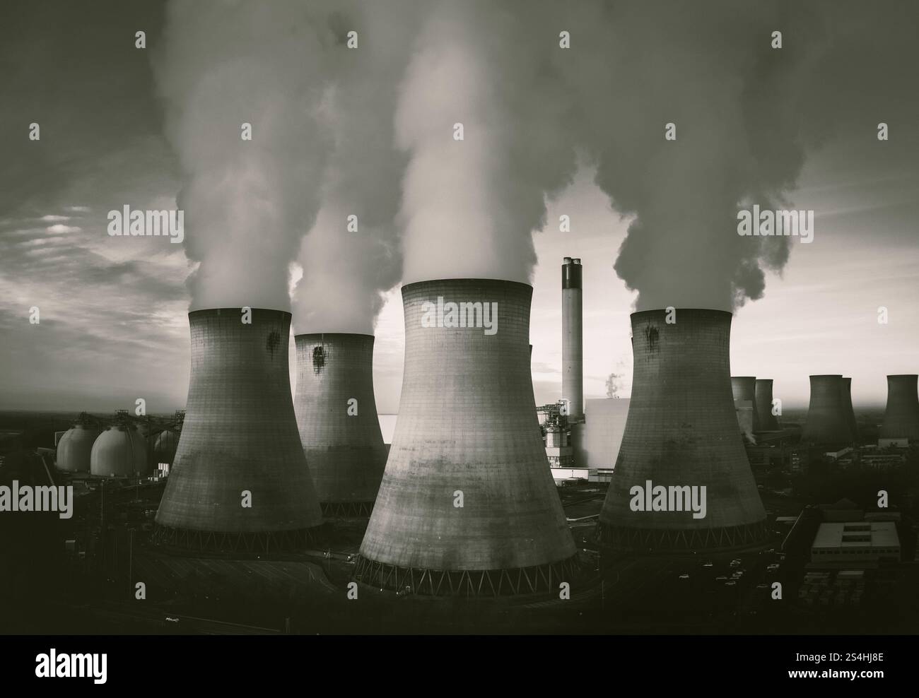 Eine vertikale Luftaufnahme einer Gruppe von Kühltürmen in einem Kohlekraftwerk mit Kohlendioxidemissionen in einem schmutzigen oder verschmutzten Luftkonzept in Stockfoto