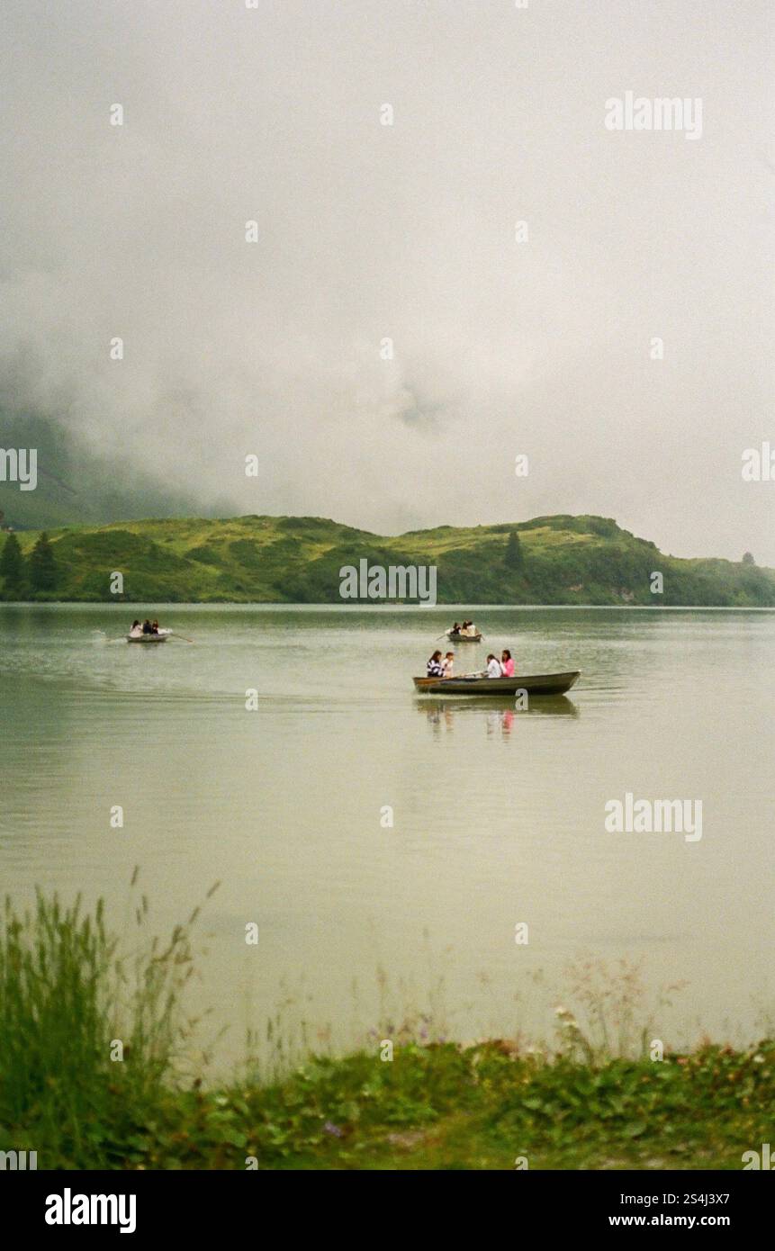 Ein nebeliger, nebelbedeckter Teich mit einem Boot, das auf dem stillen Wasser driftet. Ruhig, träumerisch, friedlich. Auf Film aufgenommen Stockfoto