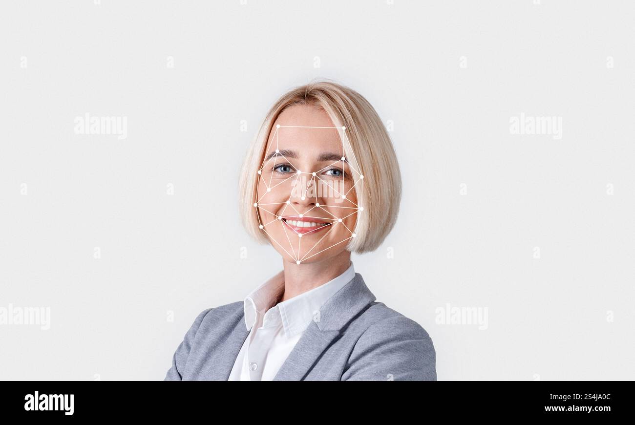 Eine Person mit kurzen blonden Haaren lächelt selbstbewusst in einem professionellen Outfit Stockfoto
