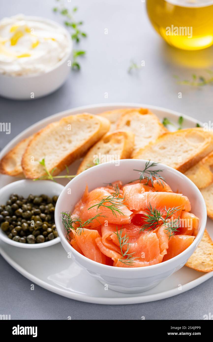 Gourmet-Teller mit geräuchertem Lachs, garniert mit Dill, gepaart mit gerösteten Baguetteschnitten und Kapern Stockfoto