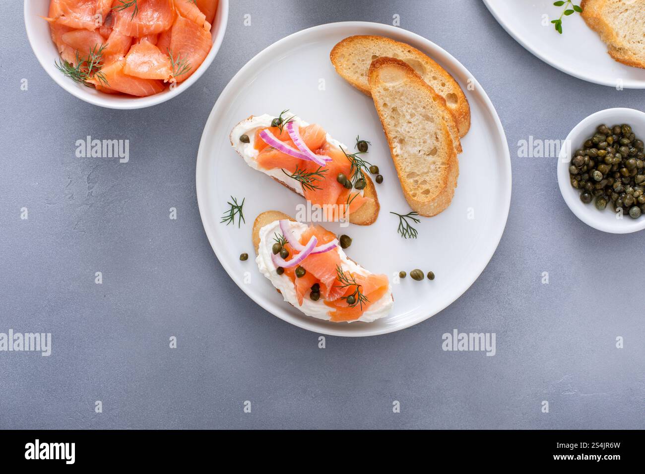 Gourmet-Teller mit geräuchertem Lachs, garniert mit Dill, gepaart mit gerösteten Baguetteschnitten und Kapern Stockfoto