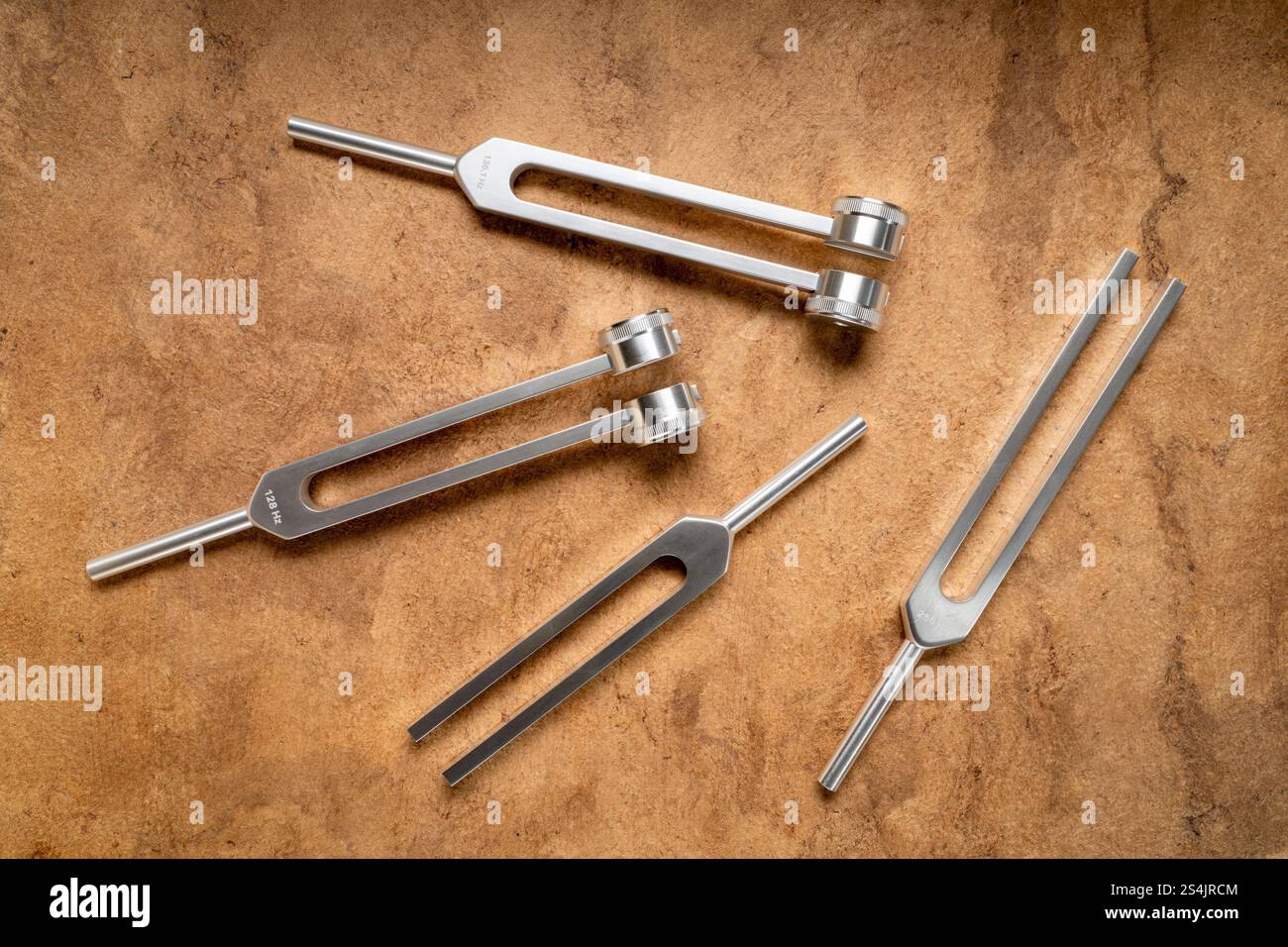 Satz gewichteter und ungewichteter Stimmgabeln aus Metall, die zum Abstimmen von Musikinstrumenten, zur Klangtherapie, zur Chakra-Heilung oder Entspannung verwendet werden. Stockfoto