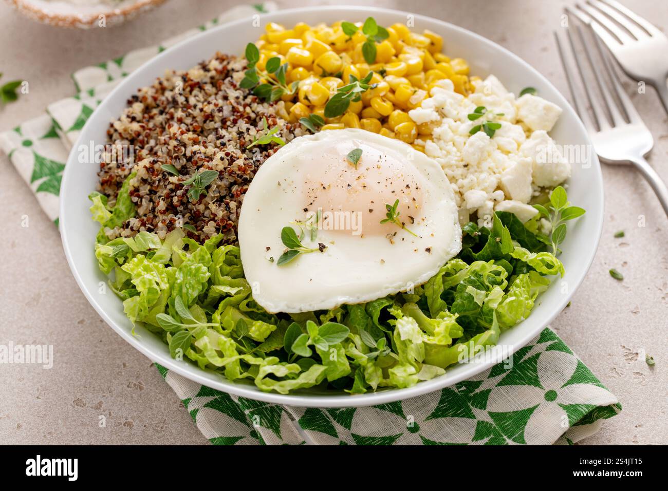 Nahrhafte Quinoa-Frühstücksschale mit Spiegelei und Zuckermais, serviert mit einer Tasse Kaffee Stockfoto