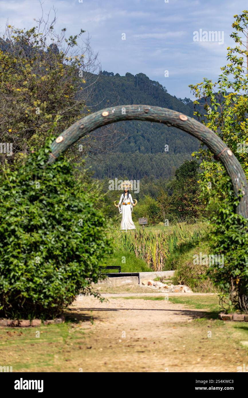 Der malerische Gartenweg führt durch ein Holzportal zur Statue der Muisca-Stämme. Kolumbianisches Kulturerbe in der Umgebung des Bergparks. Ecoparque Sabana Stockfoto