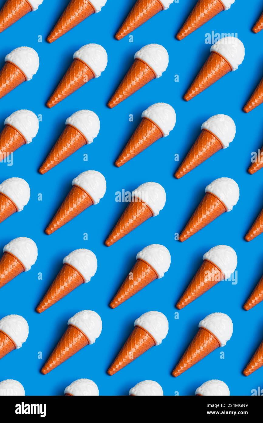 Lebendiges Muster aus Kunststoff-Eiskegel auf blauem Hintergrund, symbolisiert Kritik an Junk Food und künstlicher Diät-Kultur Highlights Umwelt Stockfoto