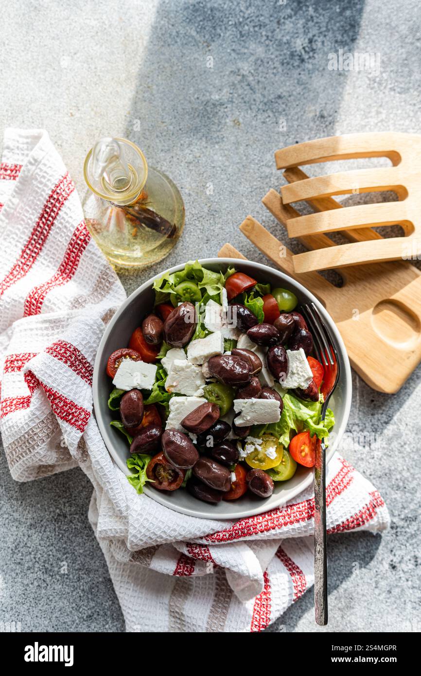 Ein lebhafter griechischer Salat mit saftigen Tomaten, knusprigem Salat, reichhaltigem Fetakäse und Oliven, perfekt für eine erfrischende Mahlzeit Stockfoto