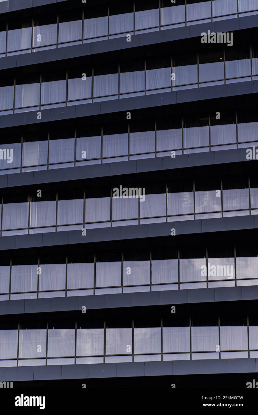 Eine detaillierte Nahaufnahme, die das moderne architektonische Design eines Gebäudes zeigt. Das Bild betont die sich wiederholenden Muster und das minimalistische A Stockfoto