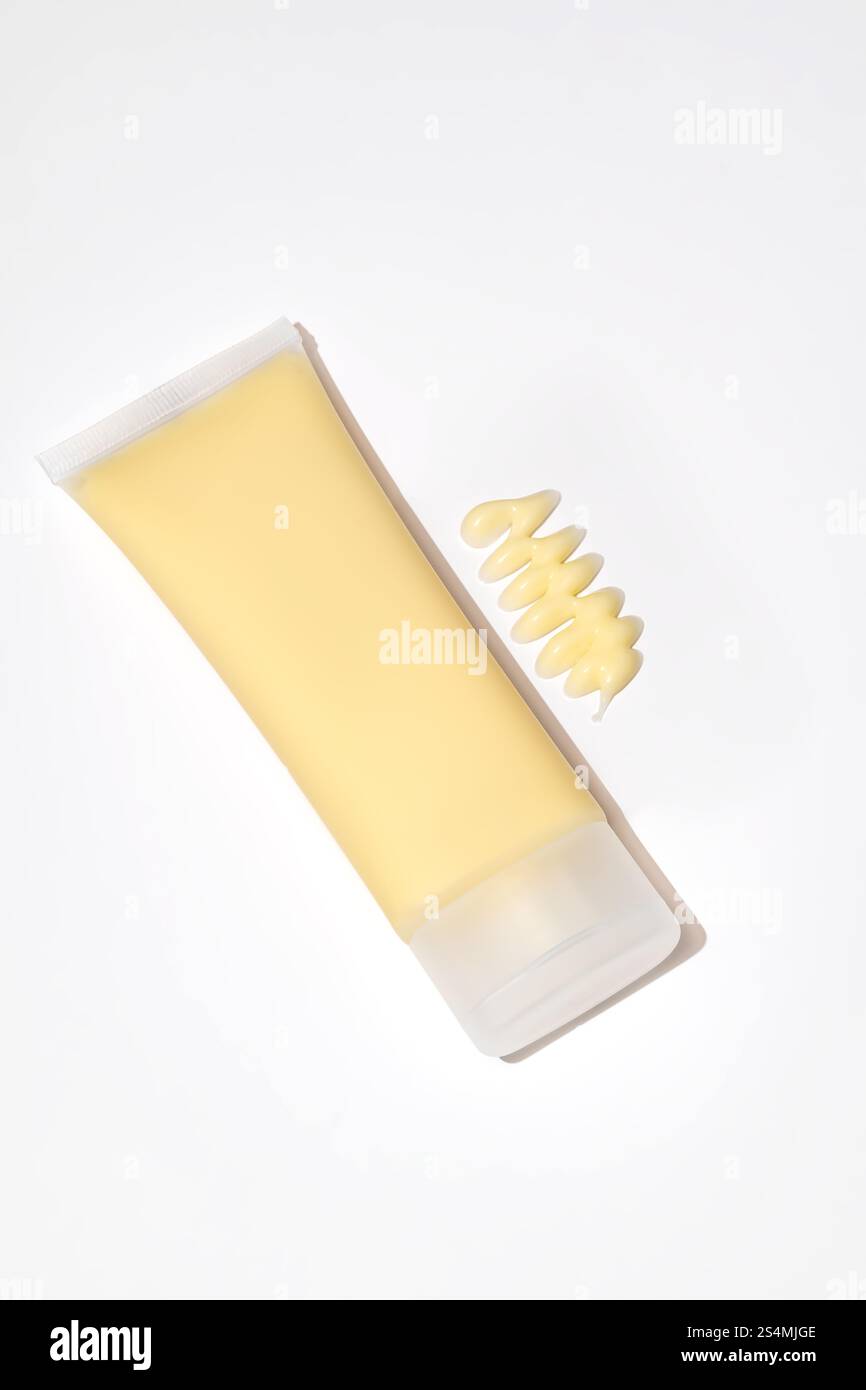 Eine hochwertige gelbe Gesichtsmaske Tube, die neben ihrem cremigen Inhalt mit manuka-Honig präsentiert wird, um Anti-Aging-Vorteile zu erzielen. Das Design wird geleert Stockfoto
