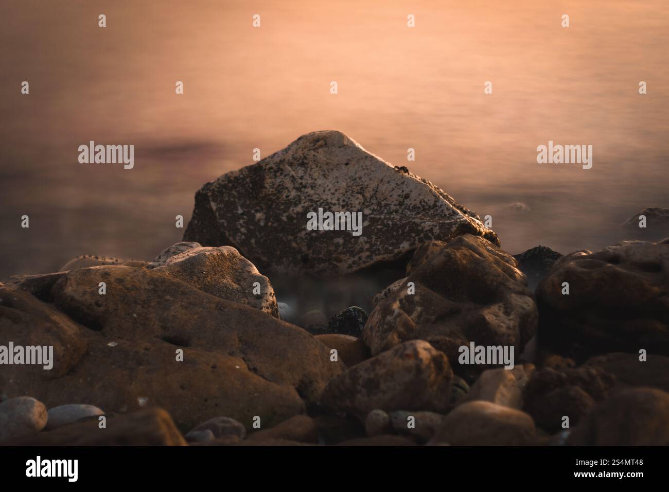 Strandlandschaft aus Steinen mit seidigen Wellen Stockfoto
