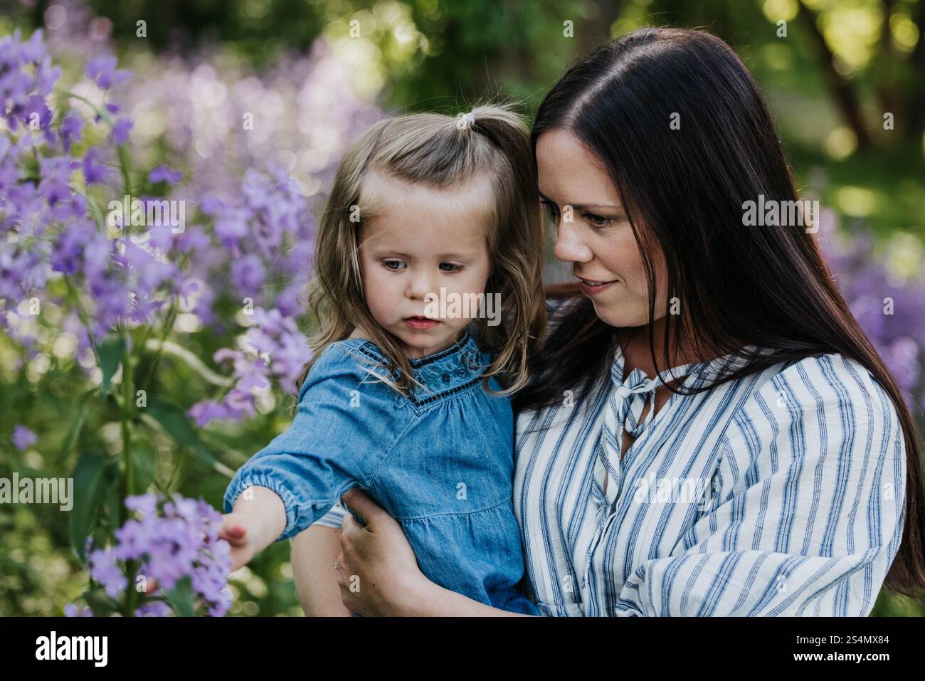 Mutter und Tochter stehen zusammen im Feld der Wildblumen Stockfoto
