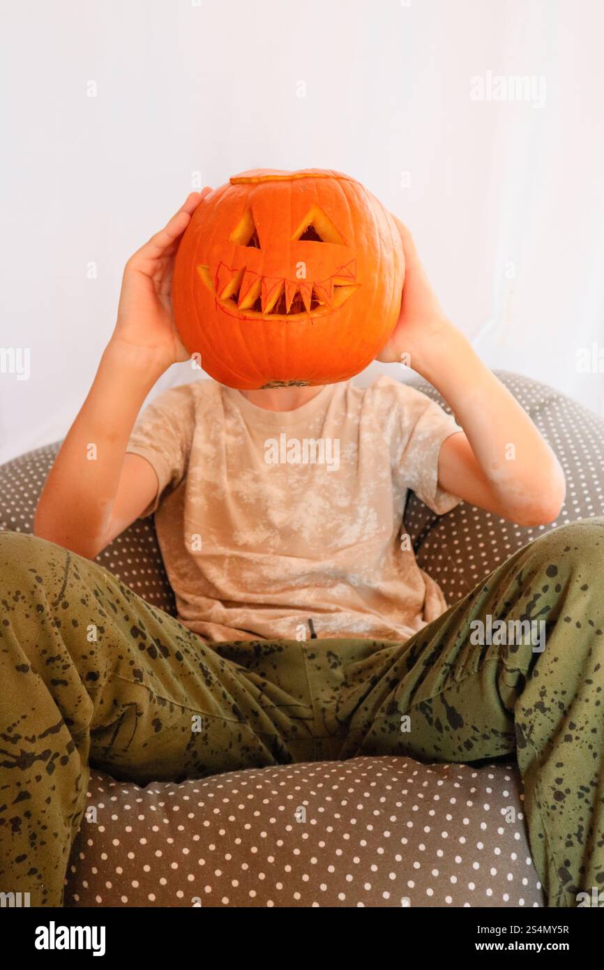 Junge mit einem Kürbis auf dem Kopf für Halloween Spaß Stockfoto