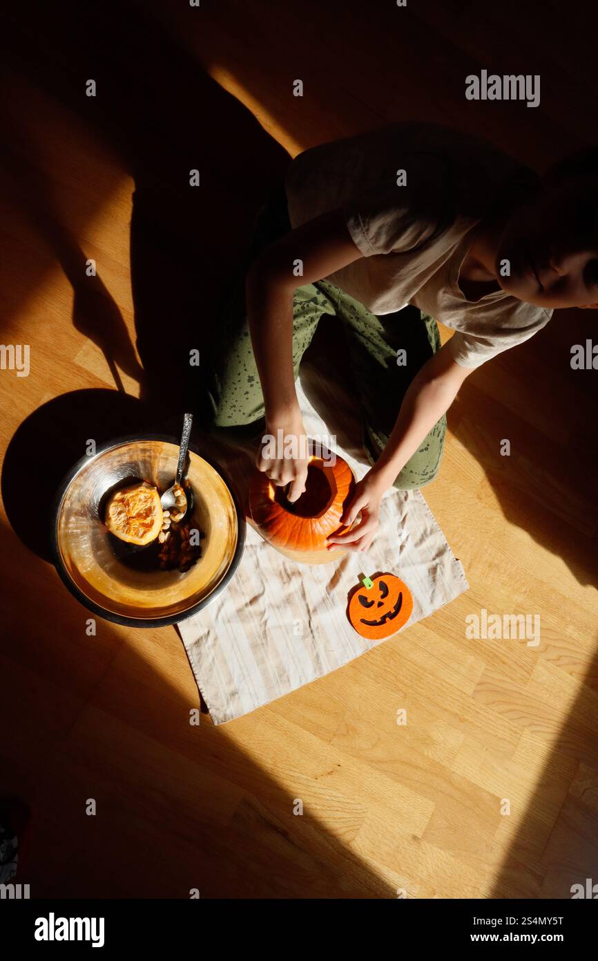Junge schnitzt einen Kürbis für Halloween Stockfoto