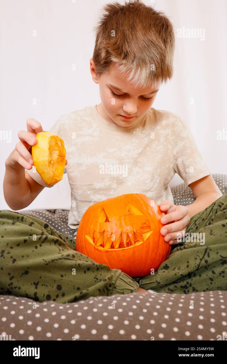 Junge, der mit einem geschnitzten Kürbis spielt Stockfoto