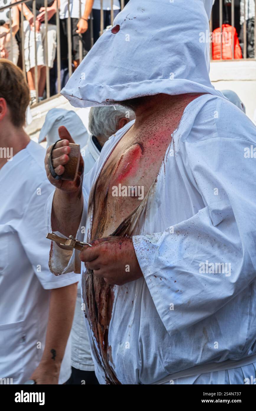 Kapuzenmänner, genannt „battenti“, schlugen ihre Brust mit einem mit Nadeln besetzten Schwamm bei der Prozession der siebenjährigen Rituale in Guardia Sanframondi Stockfoto