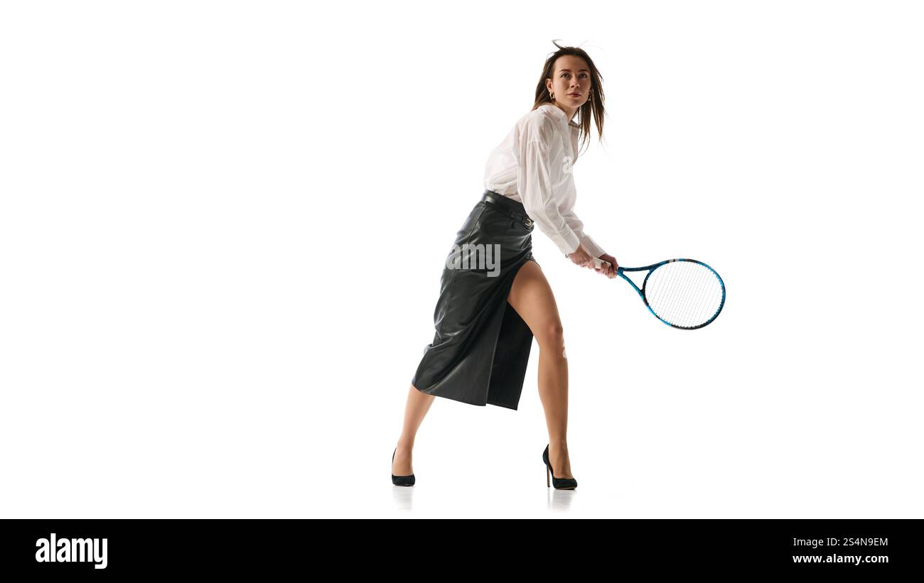 Frau im formellen Outfit, die Tennisschläger mitten in der Action packt, was die Verschmelzung von Entschlossenheit und Raffinesse im professionellen Erfolg gegen veranschaulicht Stockfoto