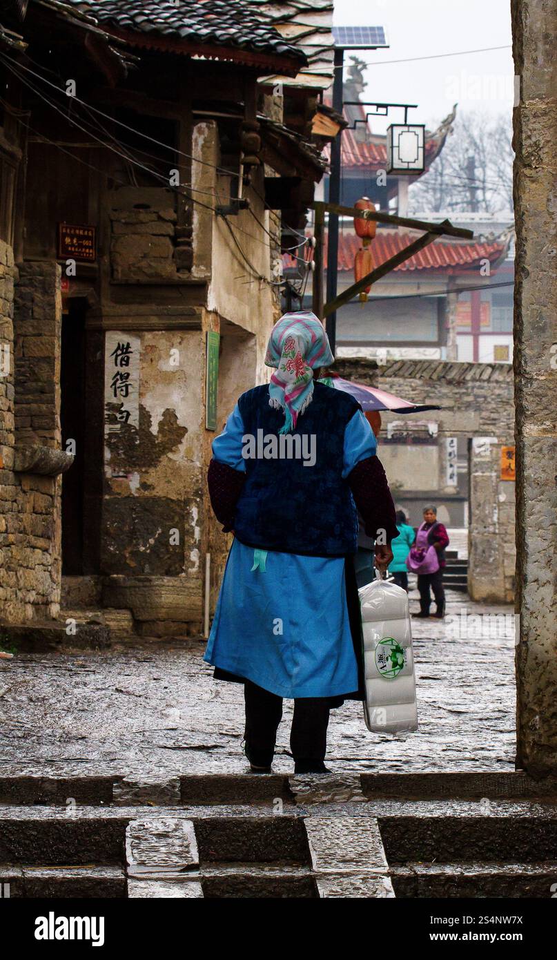 Alte Frau, die vom Einkaufen nach Hause kommt. AnShun Gebiet, Provinz Guizhou, China Stockfoto