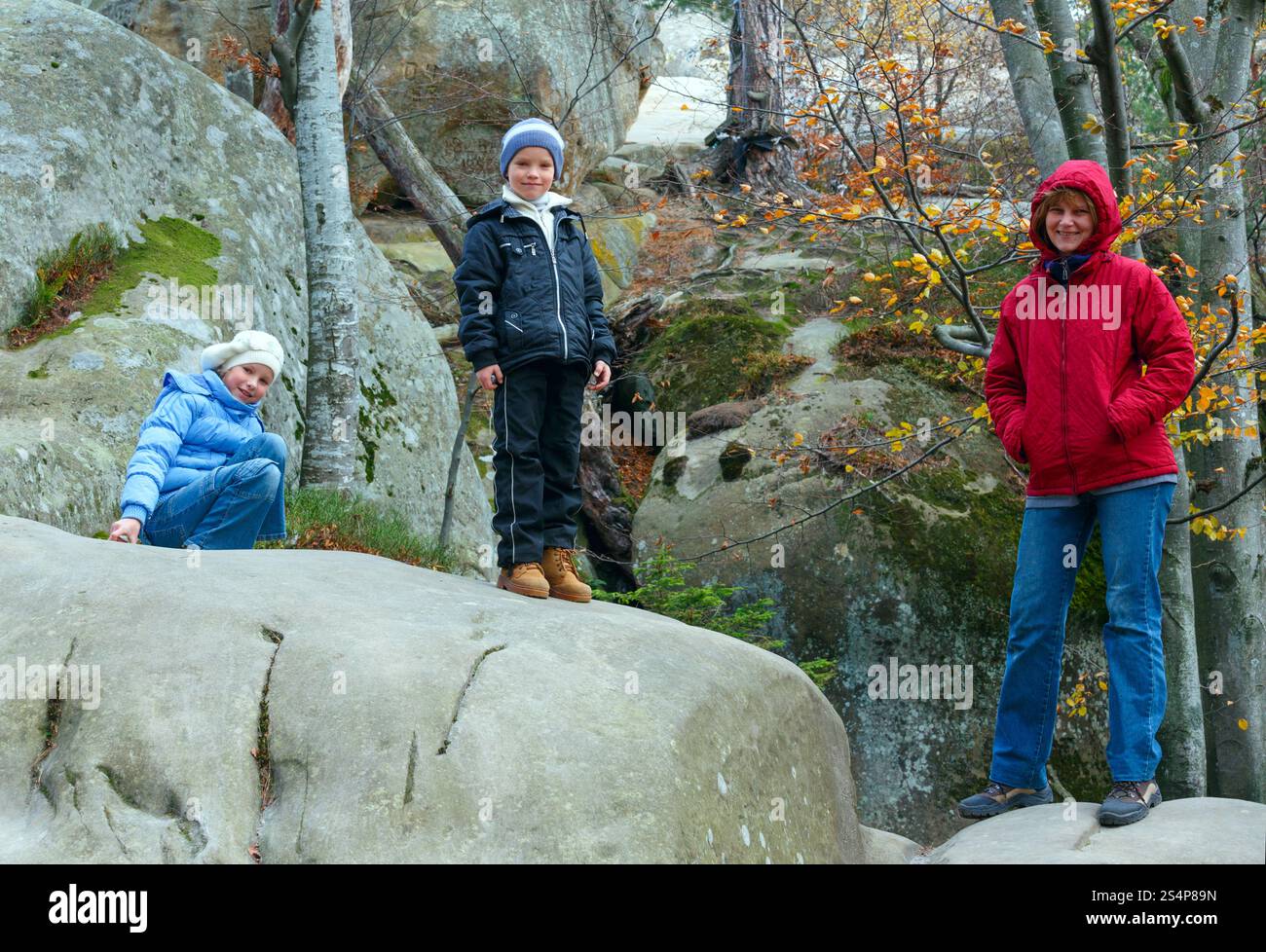 Familie im Herbstwald mit großen Hochsteinen ( Stockfoto