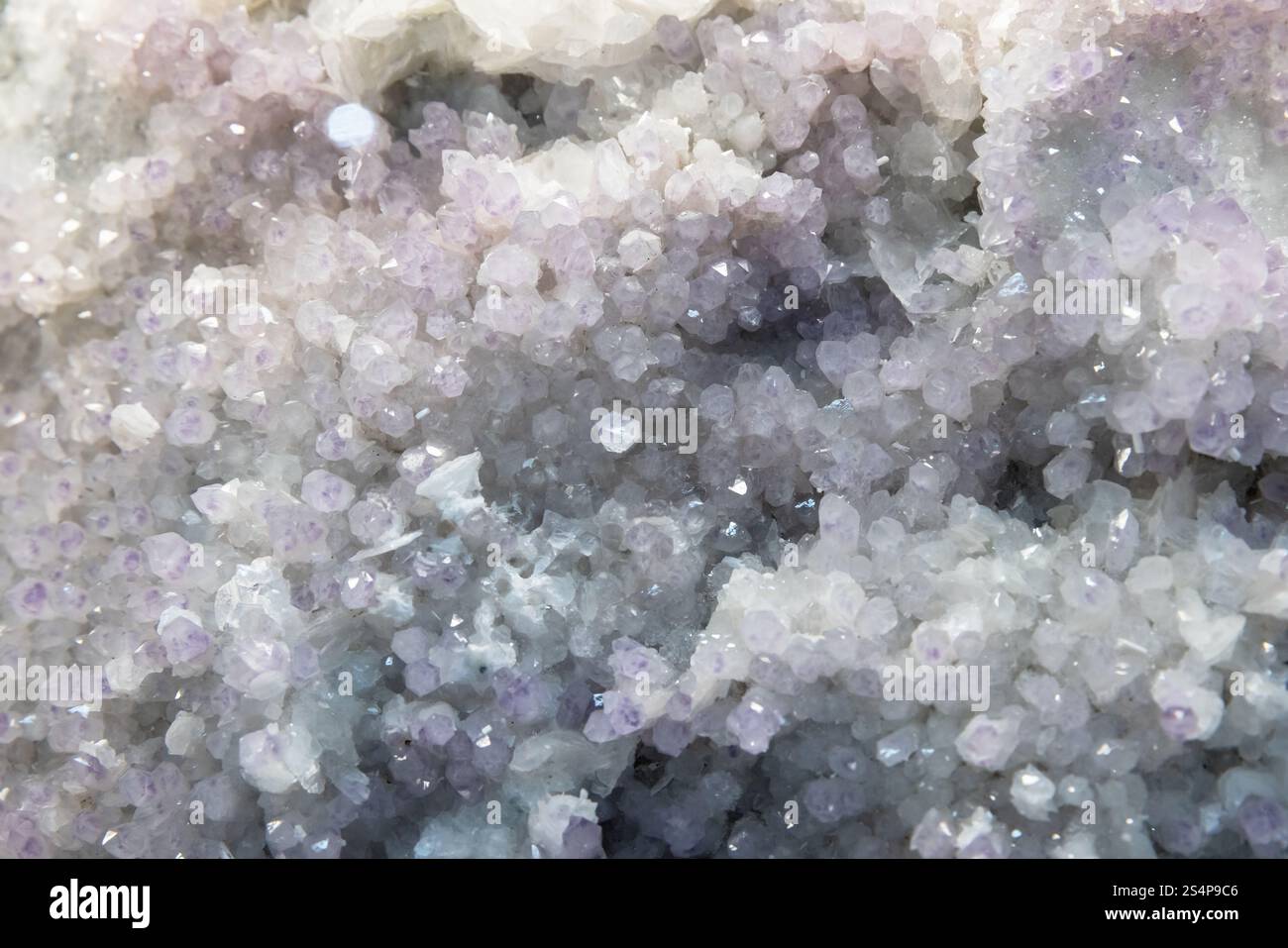 Amethyst-Drone mit kleinem Kristall. Abstrakte natürliche mineralische Hintergrundfotostruktur Stockfoto