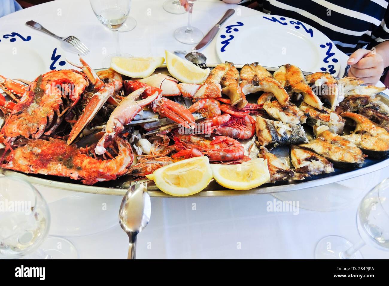 Platte mit gekochten Meeresfrüchten - gegrillter Fisch, Garnelen, Hummer, Langusten Stockfoto