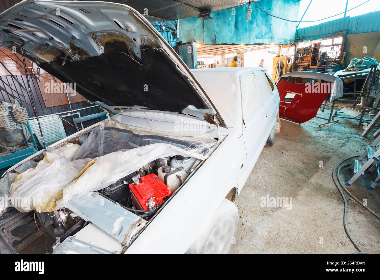 Gemälde von Altwagen in einer kleinen Dorfgarage Stockfoto
