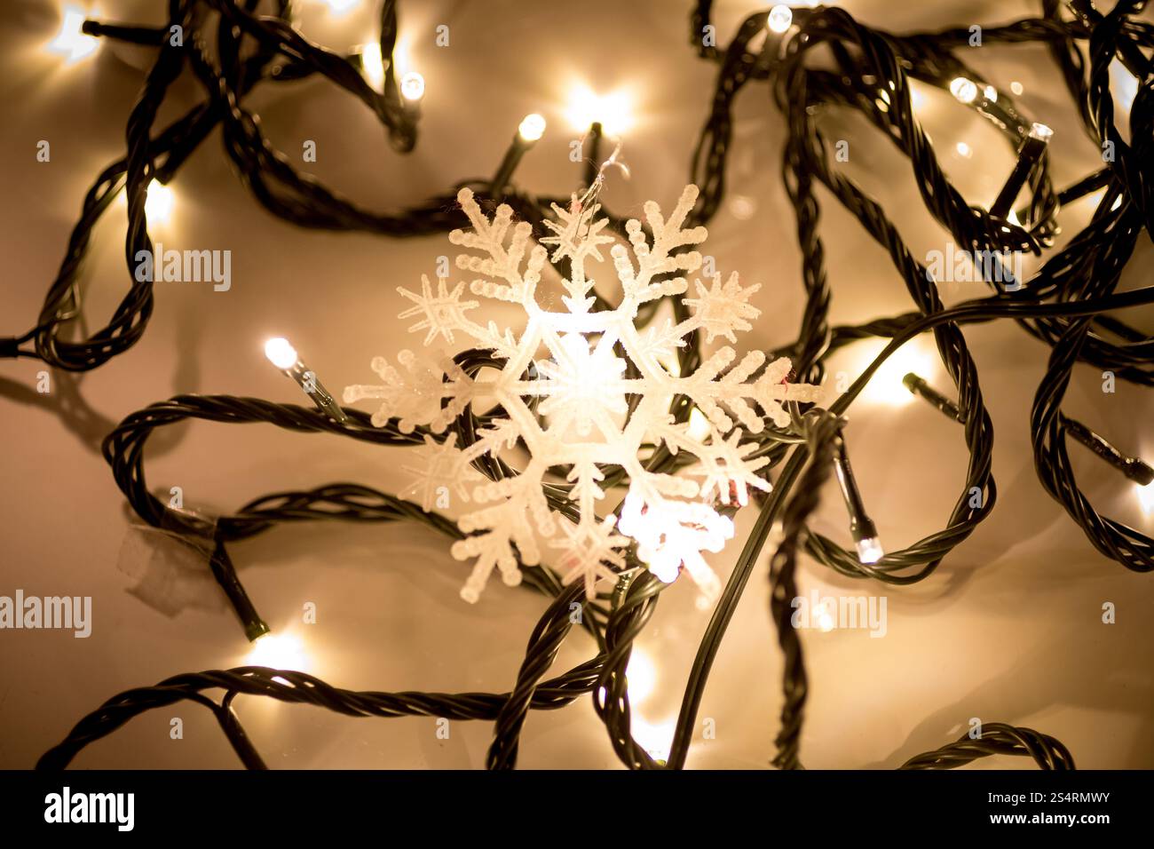 Nahaufnahme Foto von dekorativen Schneeflocken auf Weihnachtsbeleuchtung liegend Stockfoto