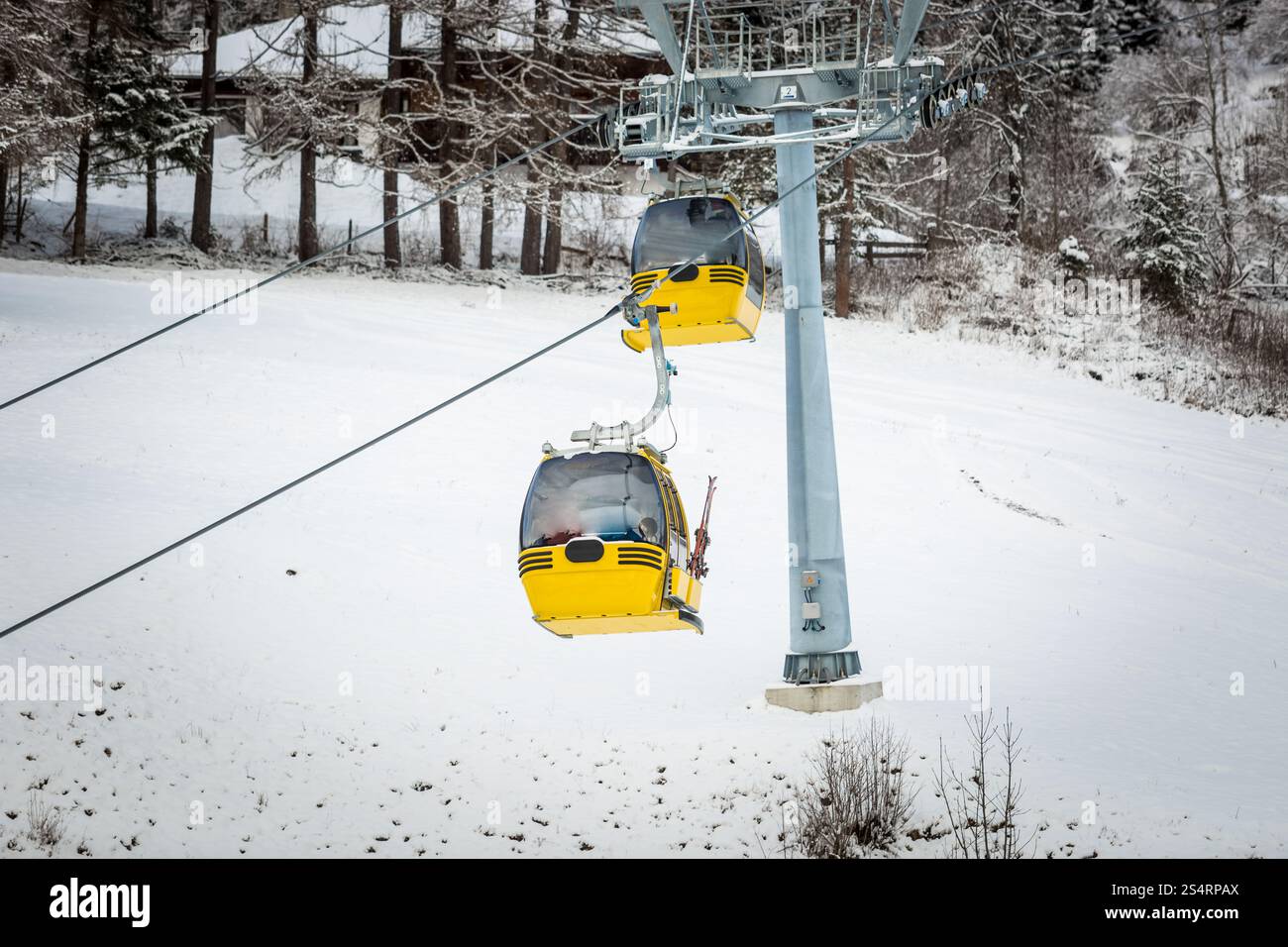 Zwei gelbe Seilbahnen auf Skipiste in Österreichische Alpen Stockfoto