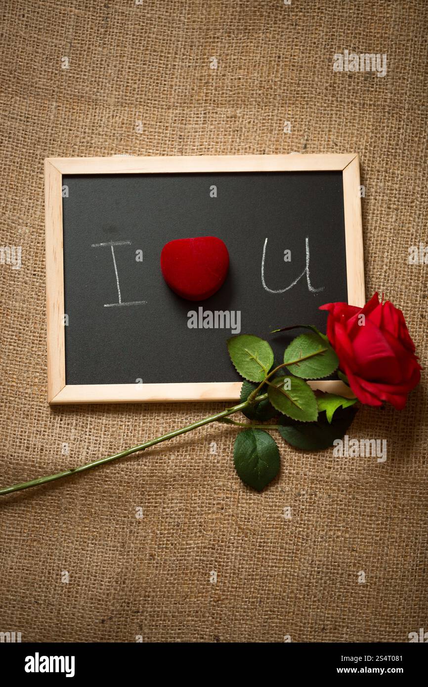 Schöne rote rose und Ring im Feld liegen an Tafel Stockfoto