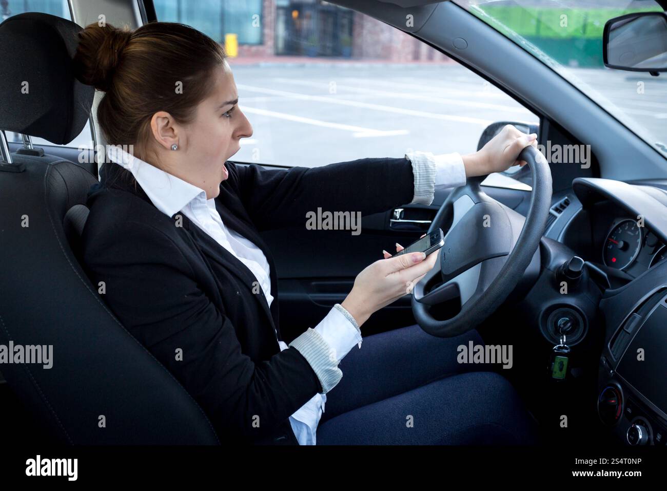 Abgelenkt Frau mit Smartphone beim Autofahren Stockfoto