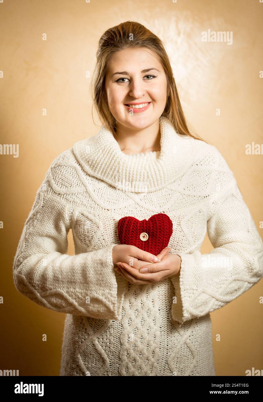 Schöne lächelnden Frau mit großen roten gestrickte Herz Stockfoto