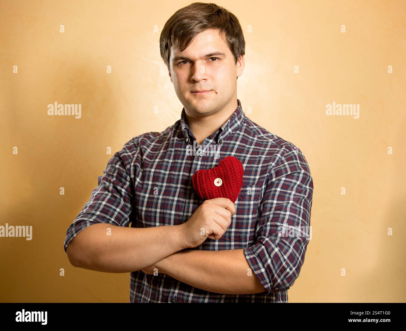 Porträt von eleganten Mann, hält rotes Herz auf der Brust Stockfoto