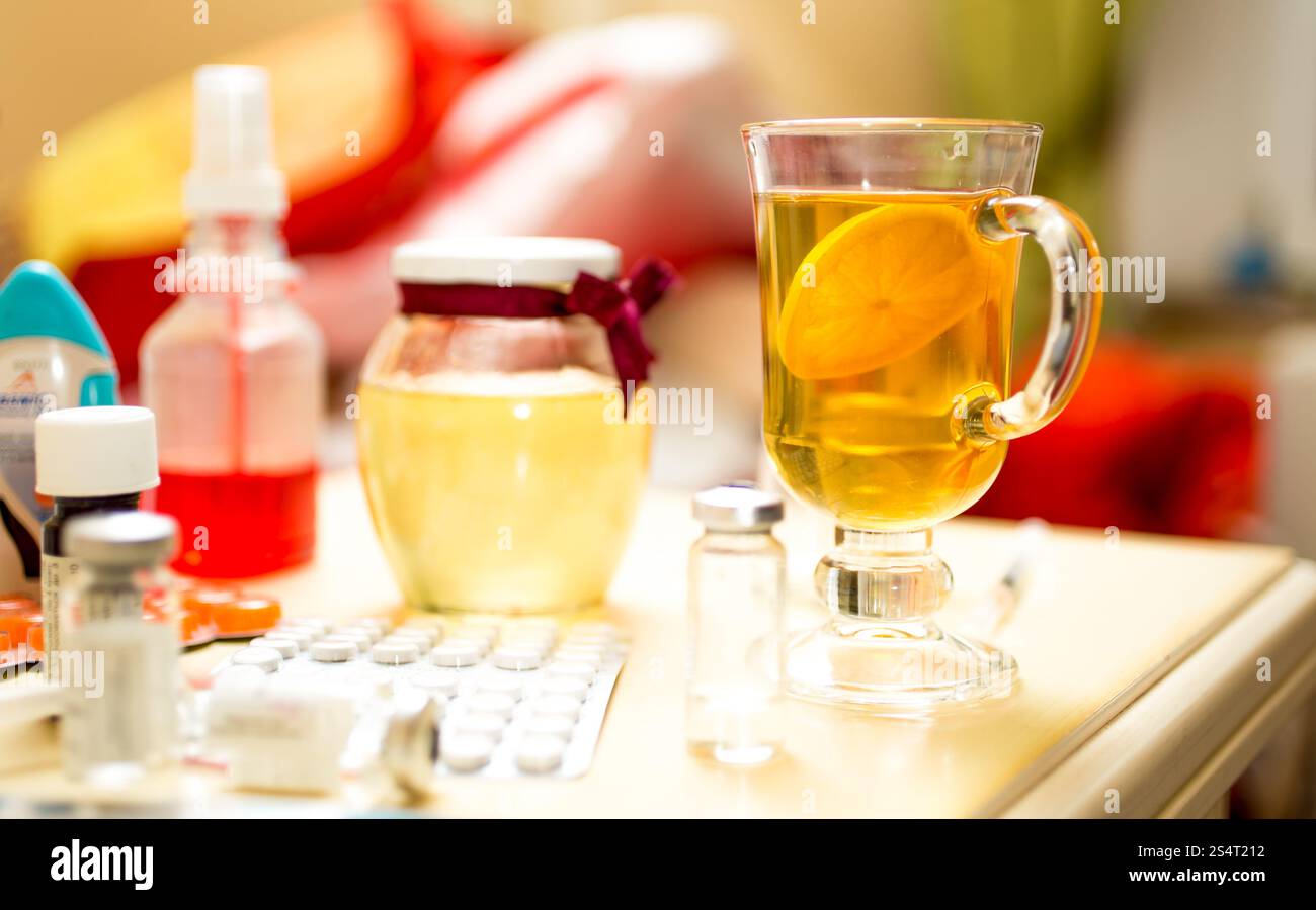 Nahaufnahme Foto von Tee und Medikamenten auf Tisch neben Bett Stockfoto