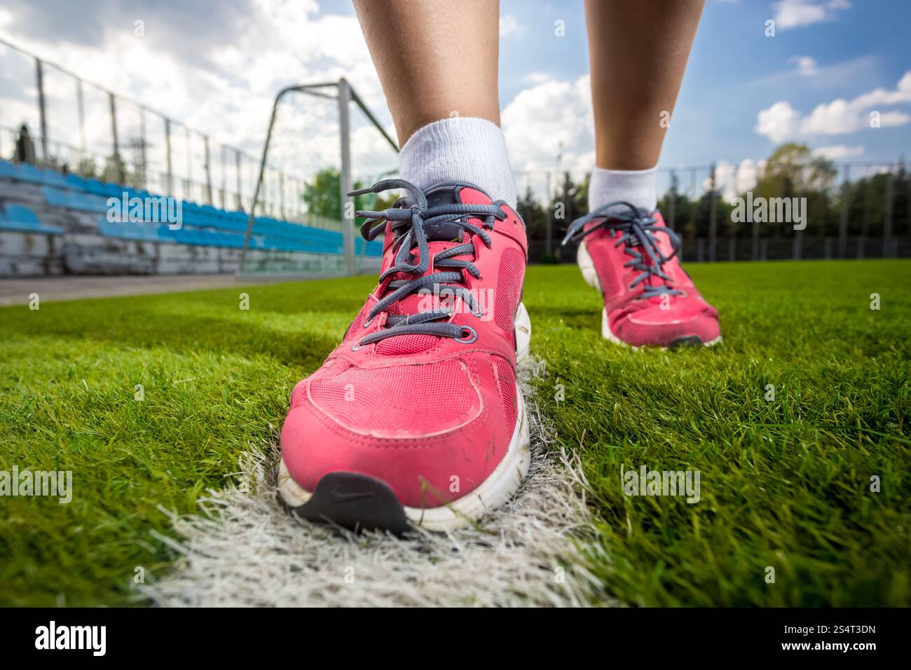 Nahaufnahme Foto rosa weibliche Turnschuhe auf Rasen-Fußballplatz Stockfoto