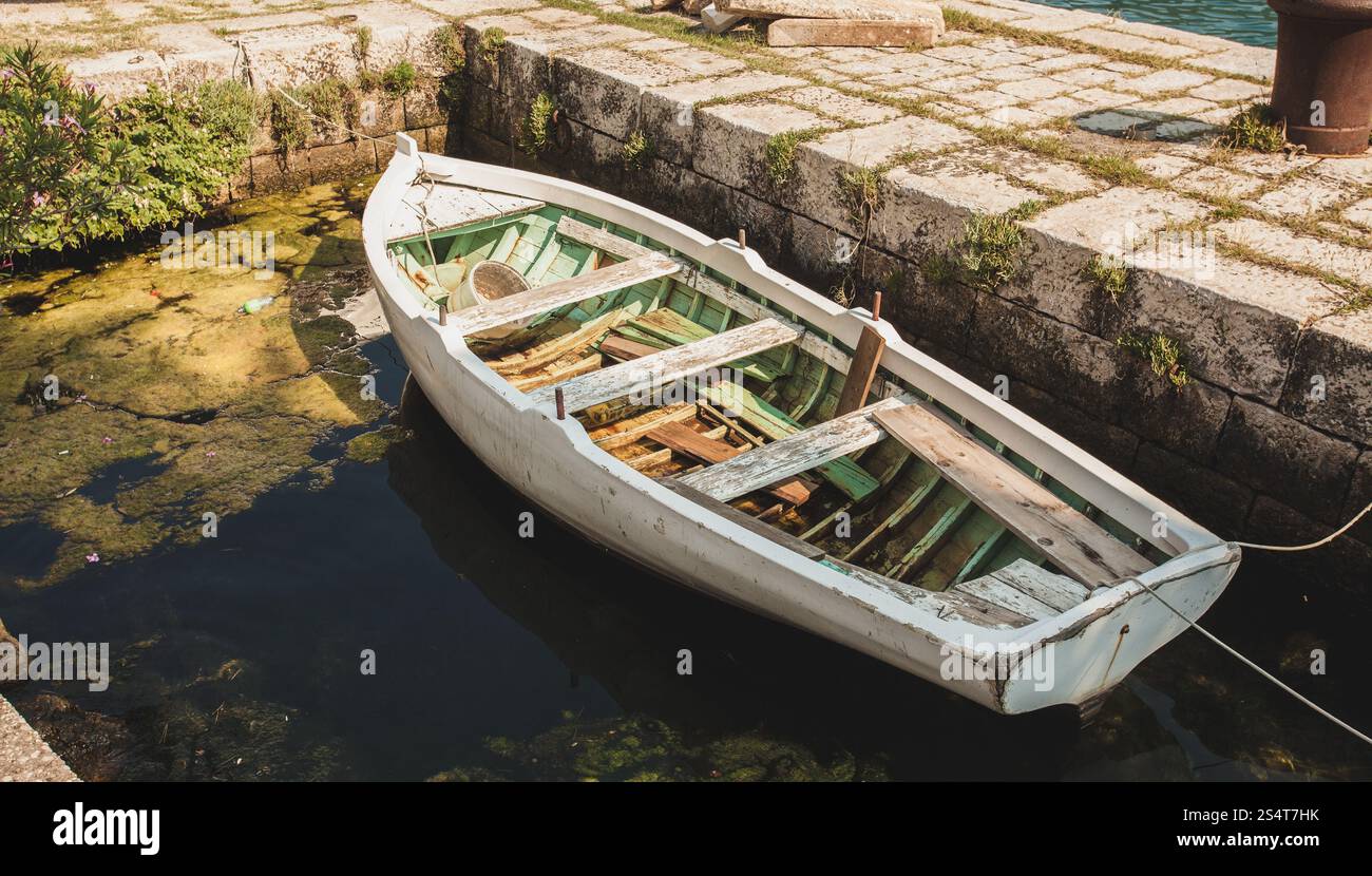 Alte hölzerne Ruderboot zu alten steinernen Liegeplatz festmachen Stockfoto