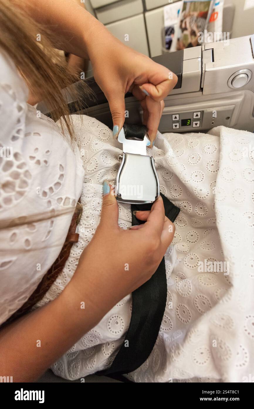 Closeup Aufnahme Frau Befestigung Sicherheitsgurt im Flugzeug Stockfoto