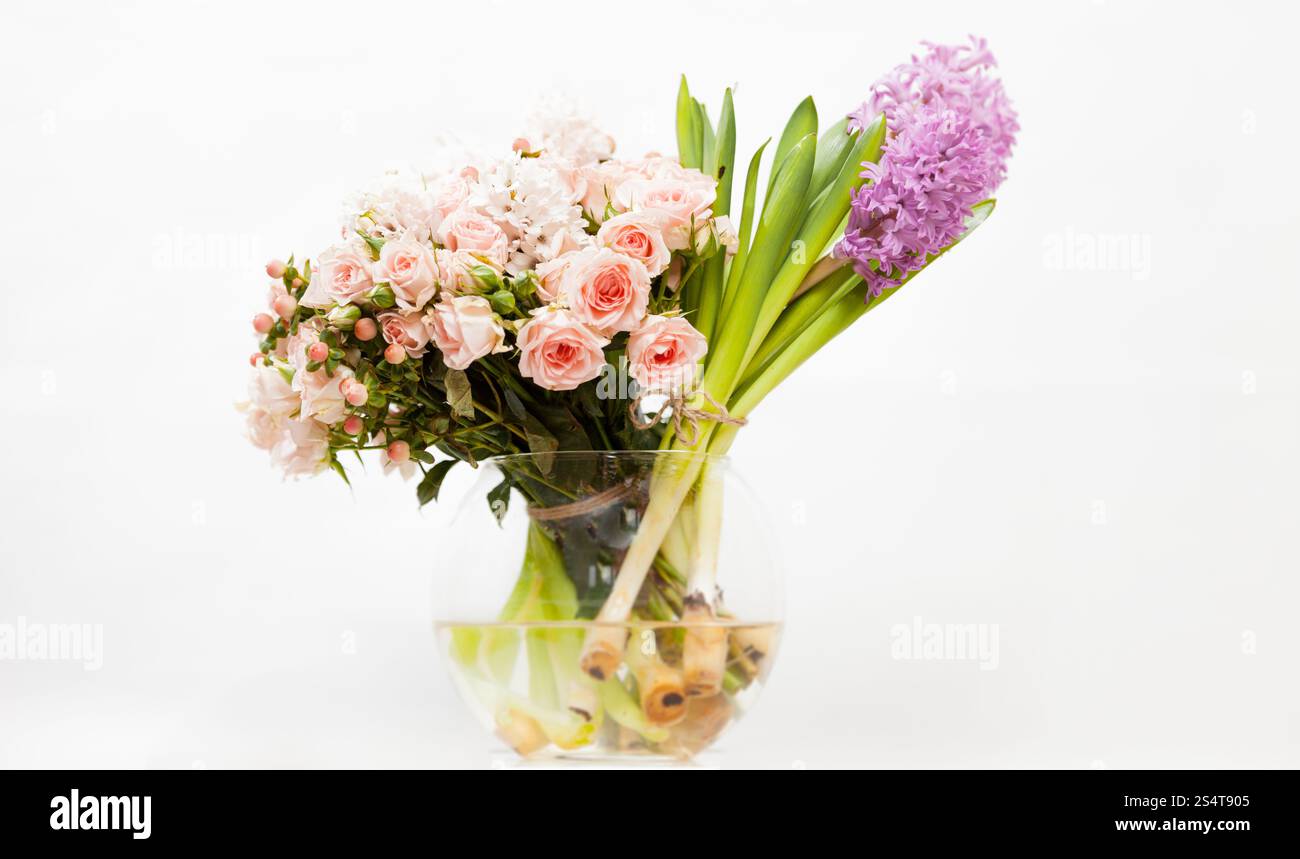 Closeup Aufnahme von bunten Blumen in Glasvase vor weißem Hintergrund Stockfoto