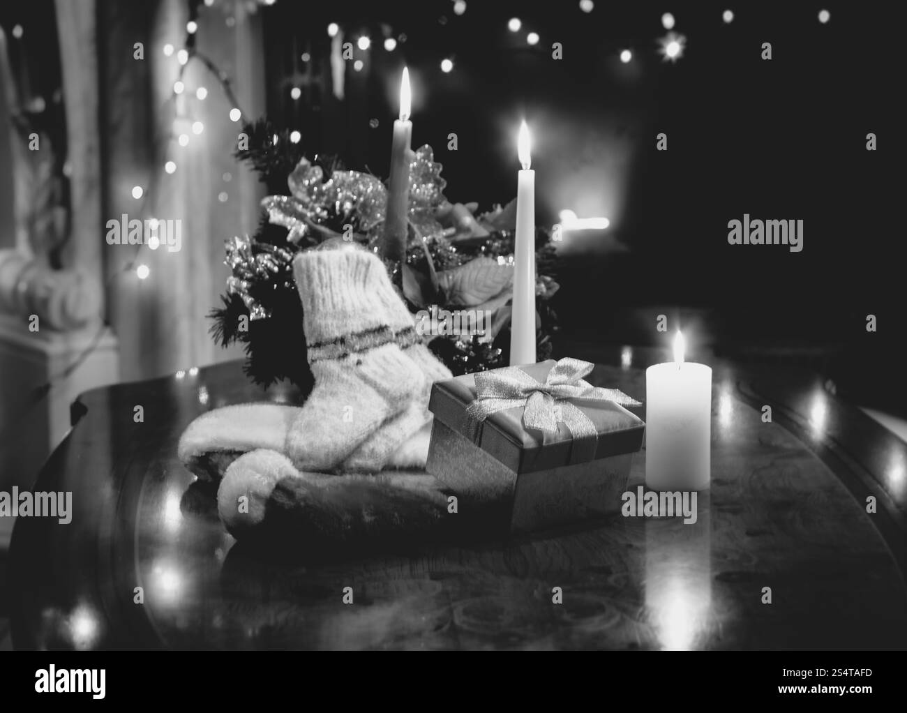 Schwarz / weiß Foto von Tisch dekoriert mit Weihnachten Kerzen, Geschenke und Socken Stockfoto