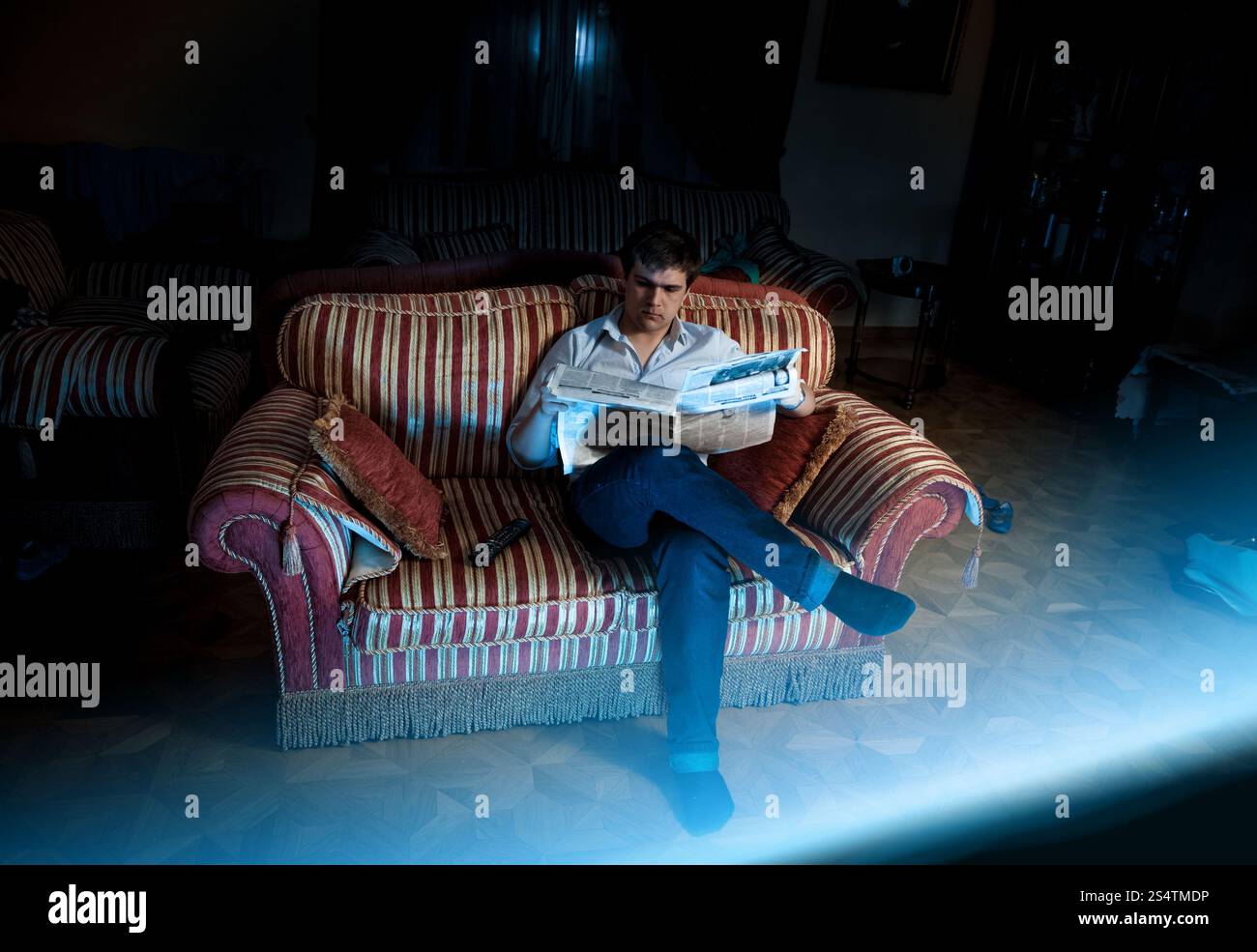 Foto von eleganten Mann vor dem Fernseher auf Sofa in der Nacht Stockfoto