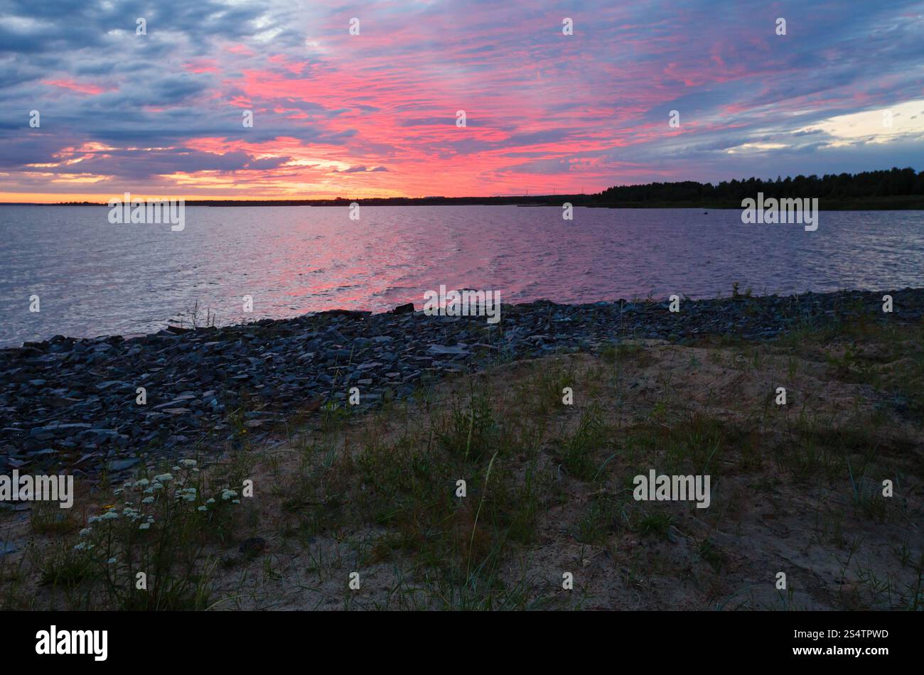 Nachthimmel mit Wolken, beleuchtet von der Sonne, an der Bucht (Finnland, polar Tag) Stockfoto