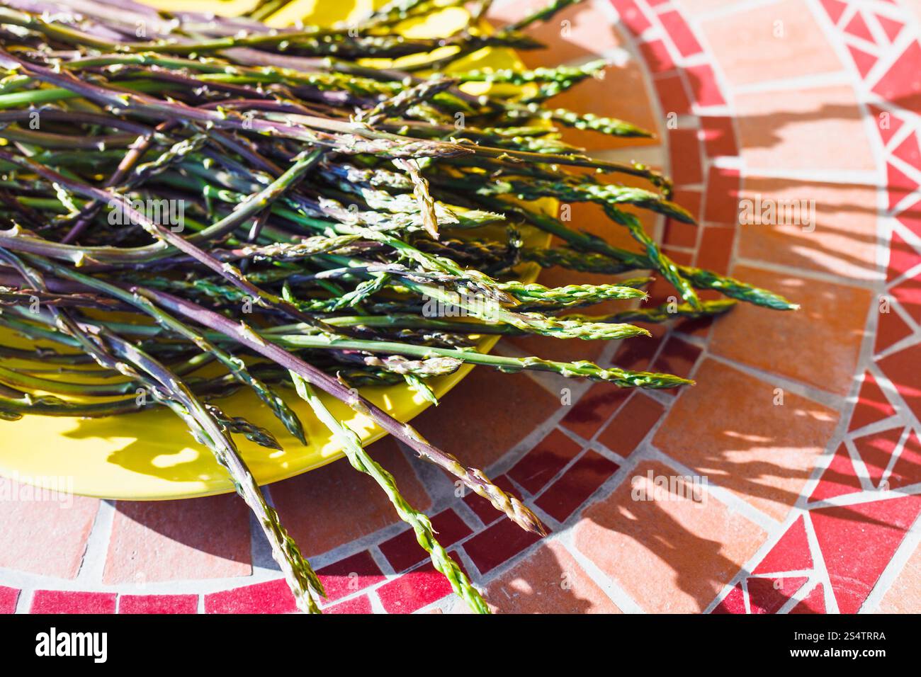 Grüner wilder Spargel auf gelbem Teller Stockfoto